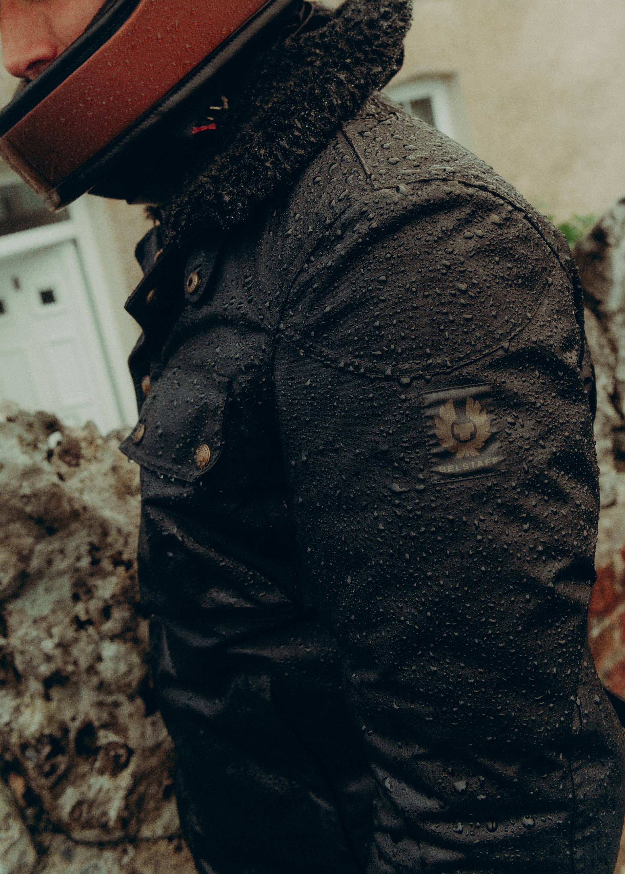 Man dressed in waxed canvas motorcycle jacket and helmet.
