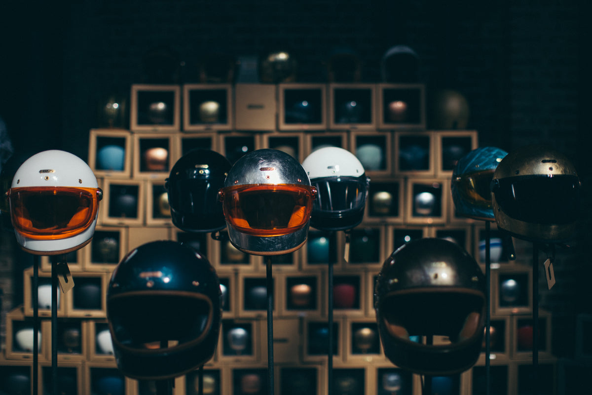 Hedon motorcycle helmets in classic designs with different colored visors and helmet accessories on display.
